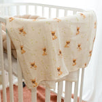 Baby Natur muslin swaddle blanket with French bulldog print and green leaves on a cream background.