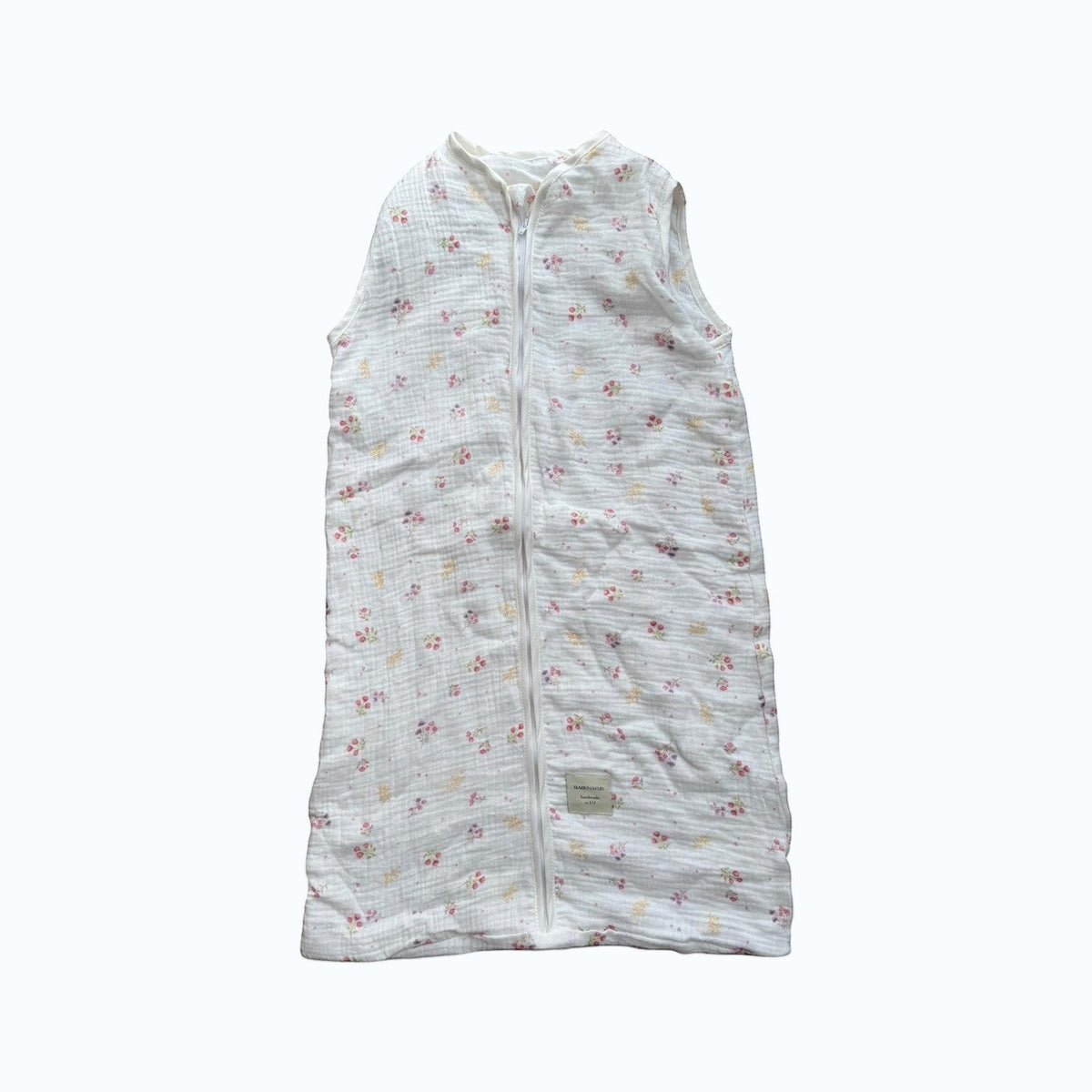 Baby Natur sleeveless sleeping bag with a delicate floral print in pink and yellow on white muslin fabric. Zipper closure.