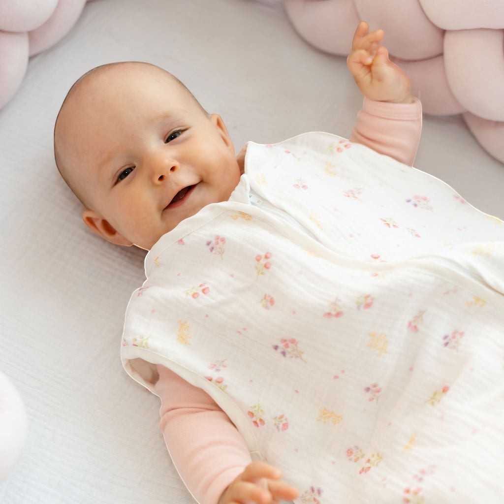 Baby Natur sleeveless sleeping bag with a floral print in white, pink, and yellow. Made from soft, breathable cotton for safe sleep.