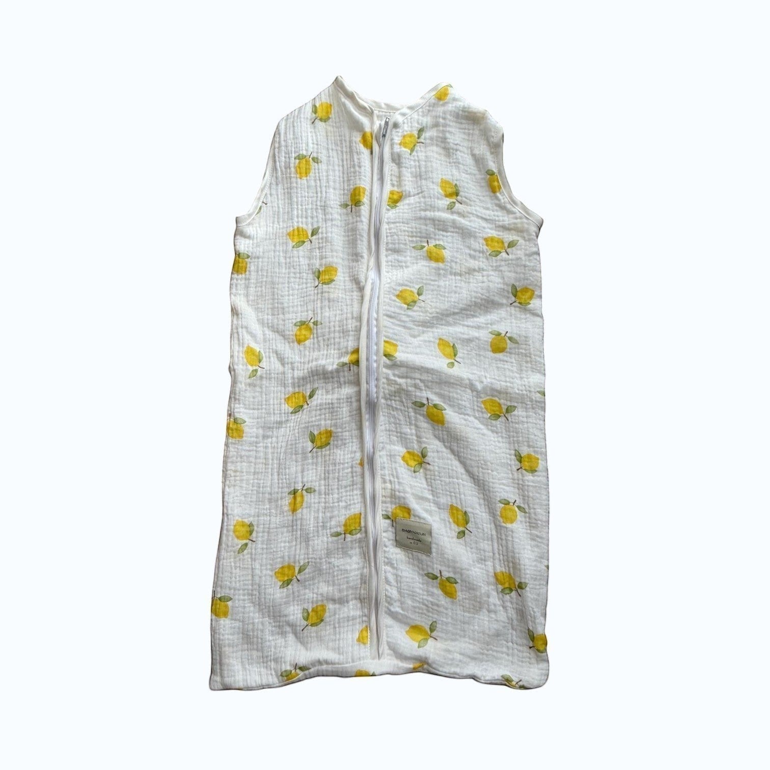 Baby Natur sleeveless sleeping bag with a white background and yellow lemon print. Made from soft, breathable cotton.