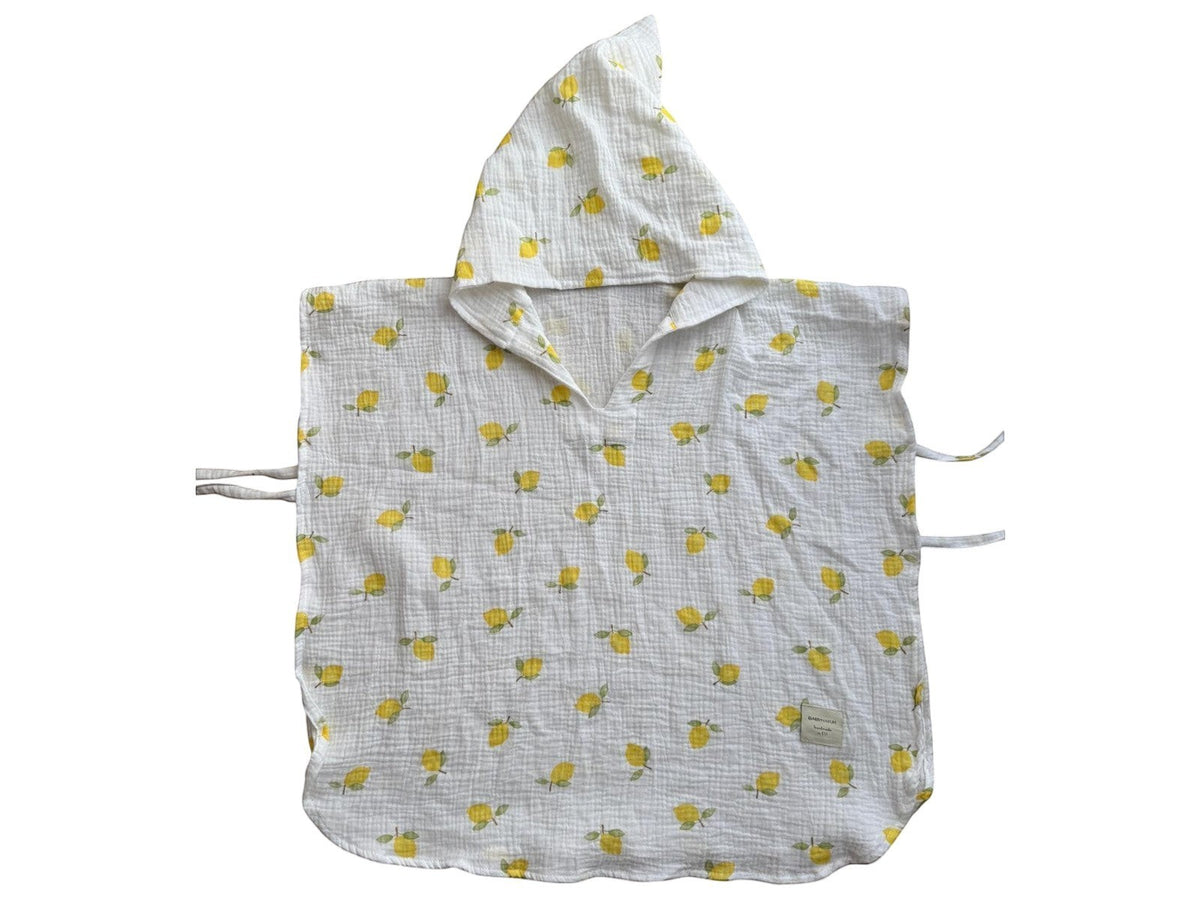 Baby Natur white muslin baby poncho with yellow lemon print and hood. Features tie closures on sides.