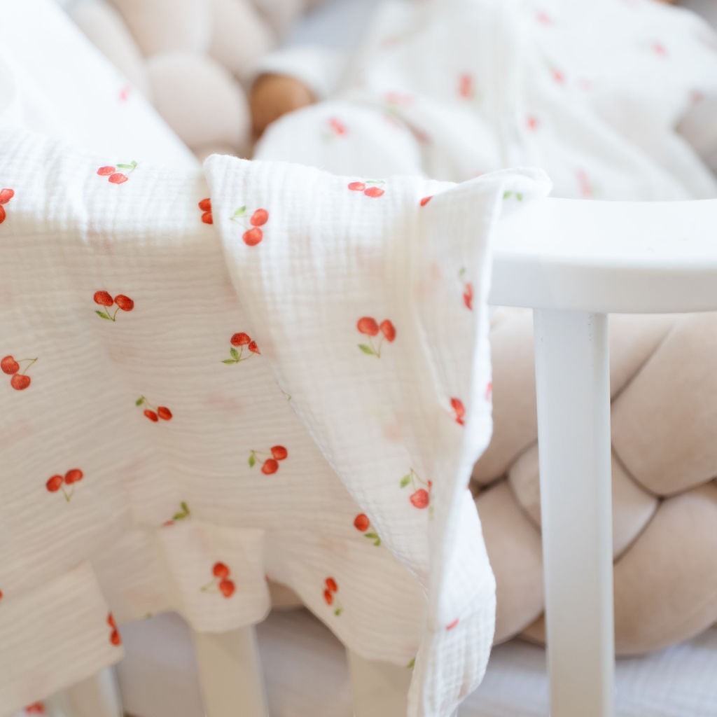 Baby NaturMuslin blanket with a cherry print, soft and breathable, perfect for cribs and strollers.