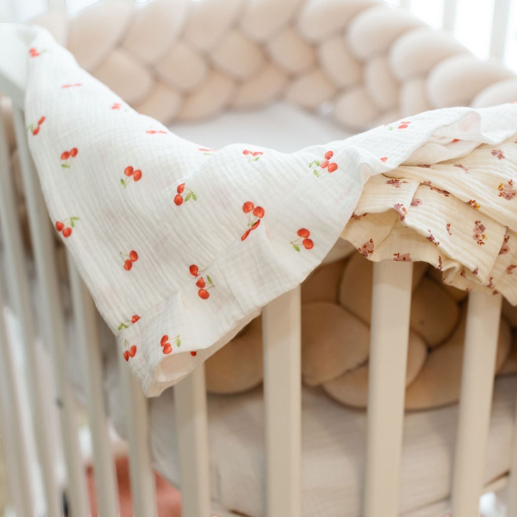 Baby Natur Muslin swaddle blanket with a cherry print and a floral print, perfect for cribs and strollers.