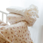 Baby Natur Muslin swaddle blankets in cream with a delicate floral print and ruffled edge. Soft and breathable.