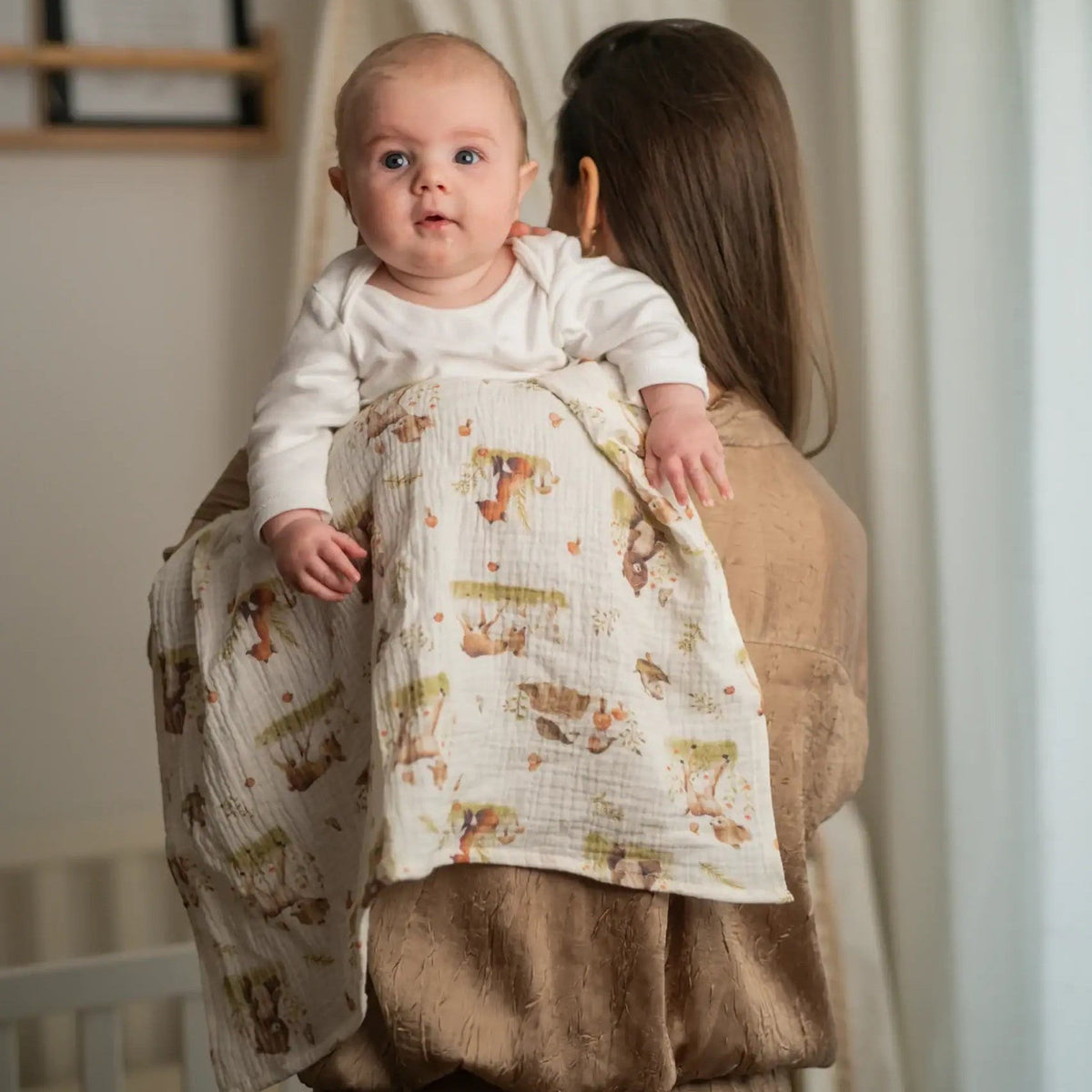 Baby NaturHere 100% cotton muslin swaddle blanket with woodland animal print, perfect for swaddling or as a burp cloth.