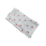 Baby NaturHere white 100% cotton muslin swaddle blanket with red cherry print. Lightweight and absorbent.